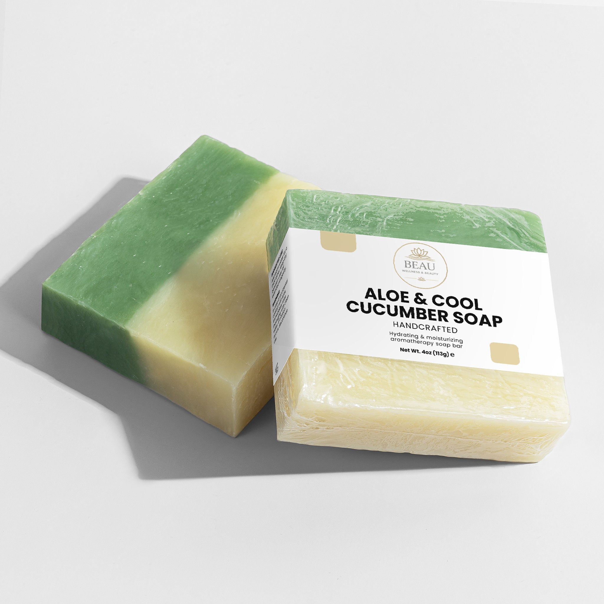 Two bars of handcrafted Aloe & Cool cucumber soap, one green and one beige, with a Beau Wellness & Beauty label on a light gray background.