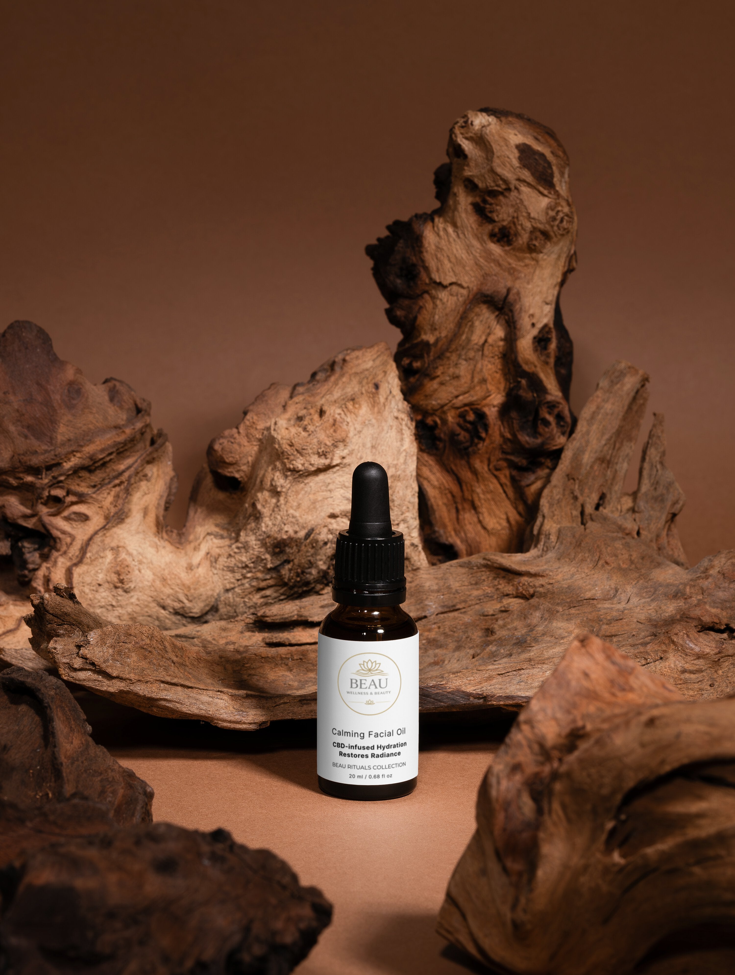 Bottle of Beau Calming CBD Facial Oil with a dropper on a brown background with wooden textures