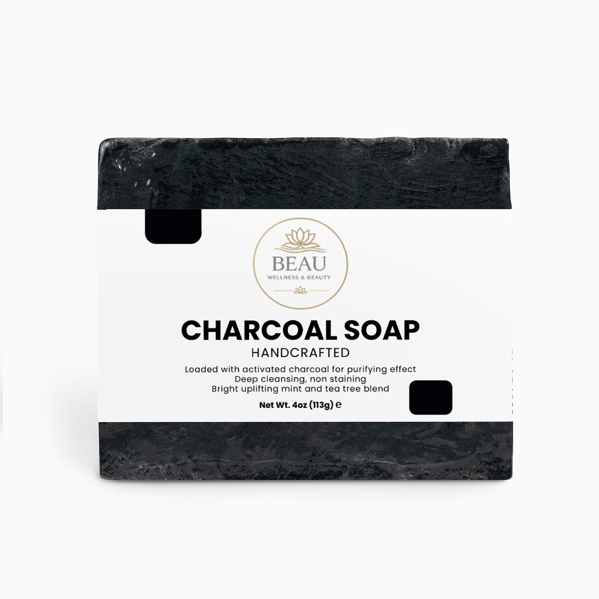 Bar of handcrafted charcoal soap with a white Beau Wellness & Beauty label on a white background