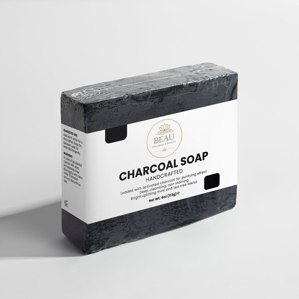 Charcoal soap bar with Beau Wellness & Beauty packaging on a light gray background