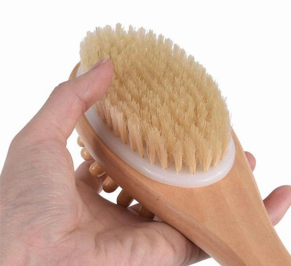 Natural boar bristle bath and body massage brush with long wooden handle for dry brushing and exfoliation, by Beau Wellness & Beauty held by hand