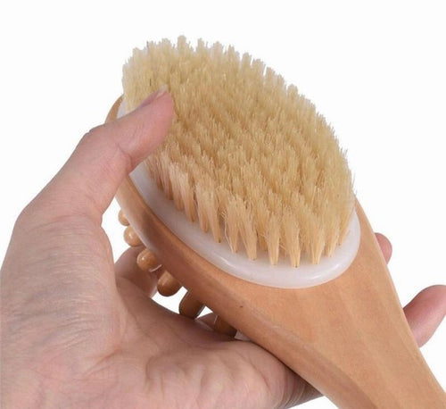 Natural boar bristle bath and body massage brush with long wooden handle for dry brushing and exfoliation, by Beau Wellness & Beauty held by hand