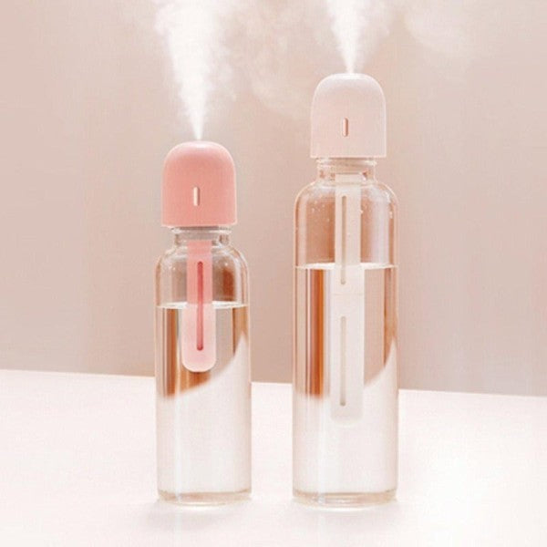 Two clear bottles with Anywhere Portable Bottle Humidifiers emitting mist on a light background