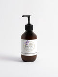 Minimalist amber pump bottle of Beau Wellness & Beauty 5% Urea + 2% Panthenol Body Cream on a clean white background