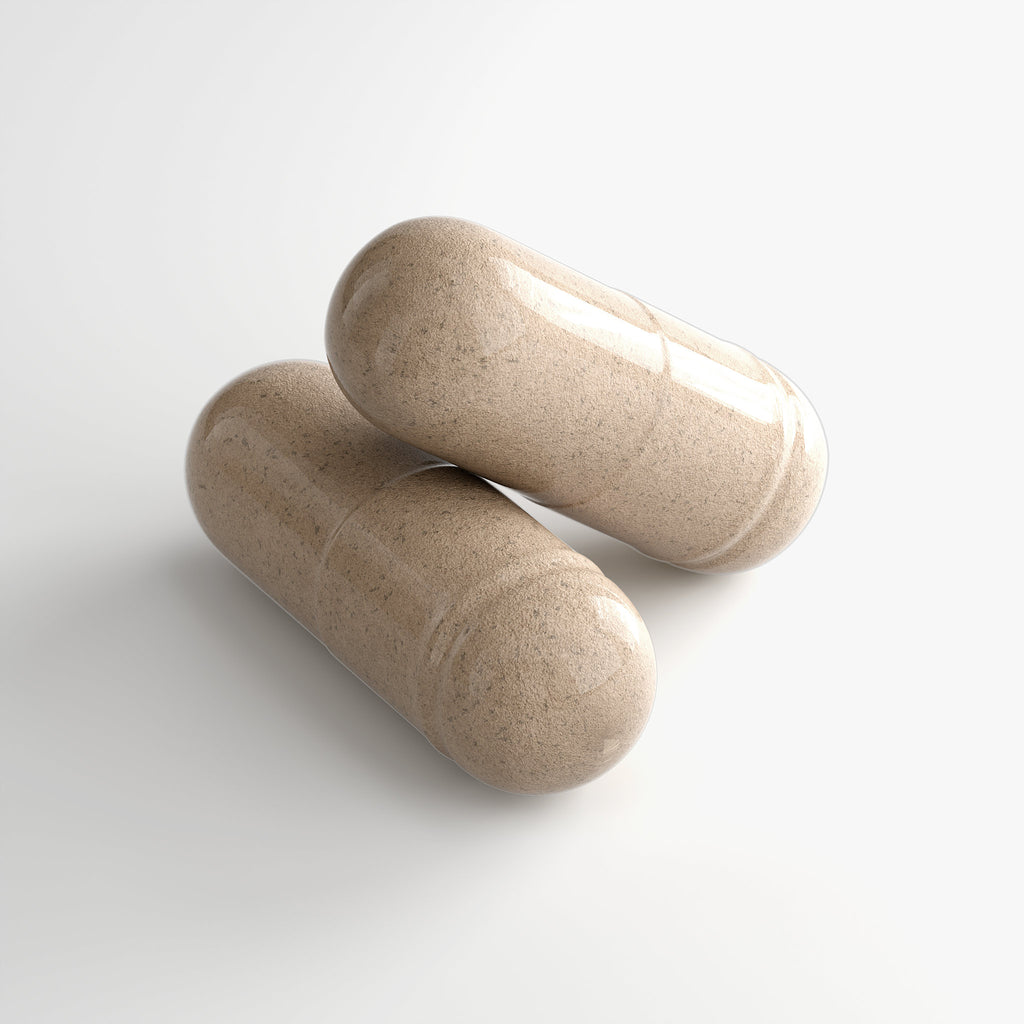 Two loose capsules of Beau Wellness Ashwagandha Plus Capsules with KSM-66 and Maca Root for Stress Relief on white background.