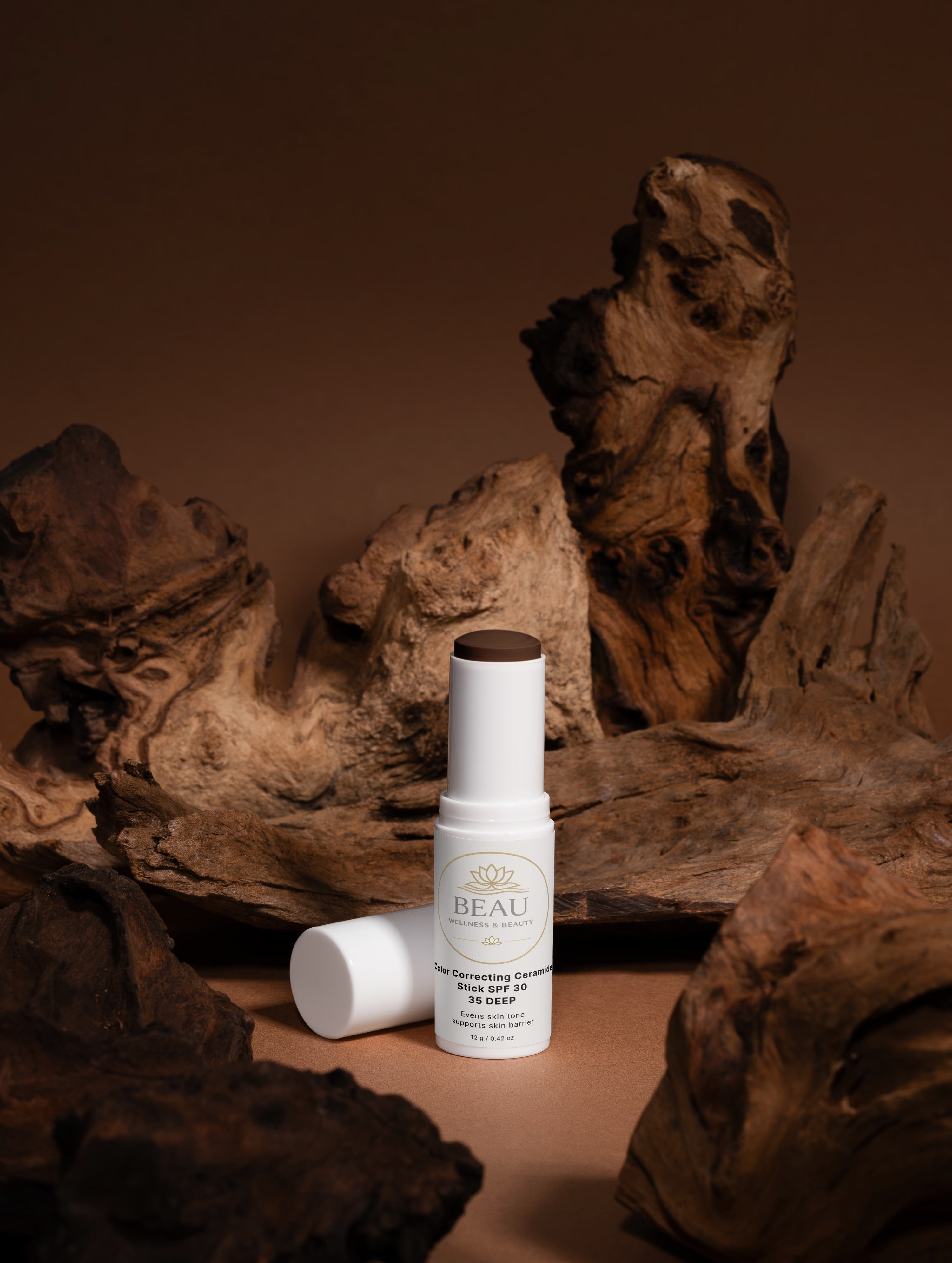 Beau Beauty CC Cream Color Correcting Ceramide Cosmetic stick with wooden pieces on a brown background
