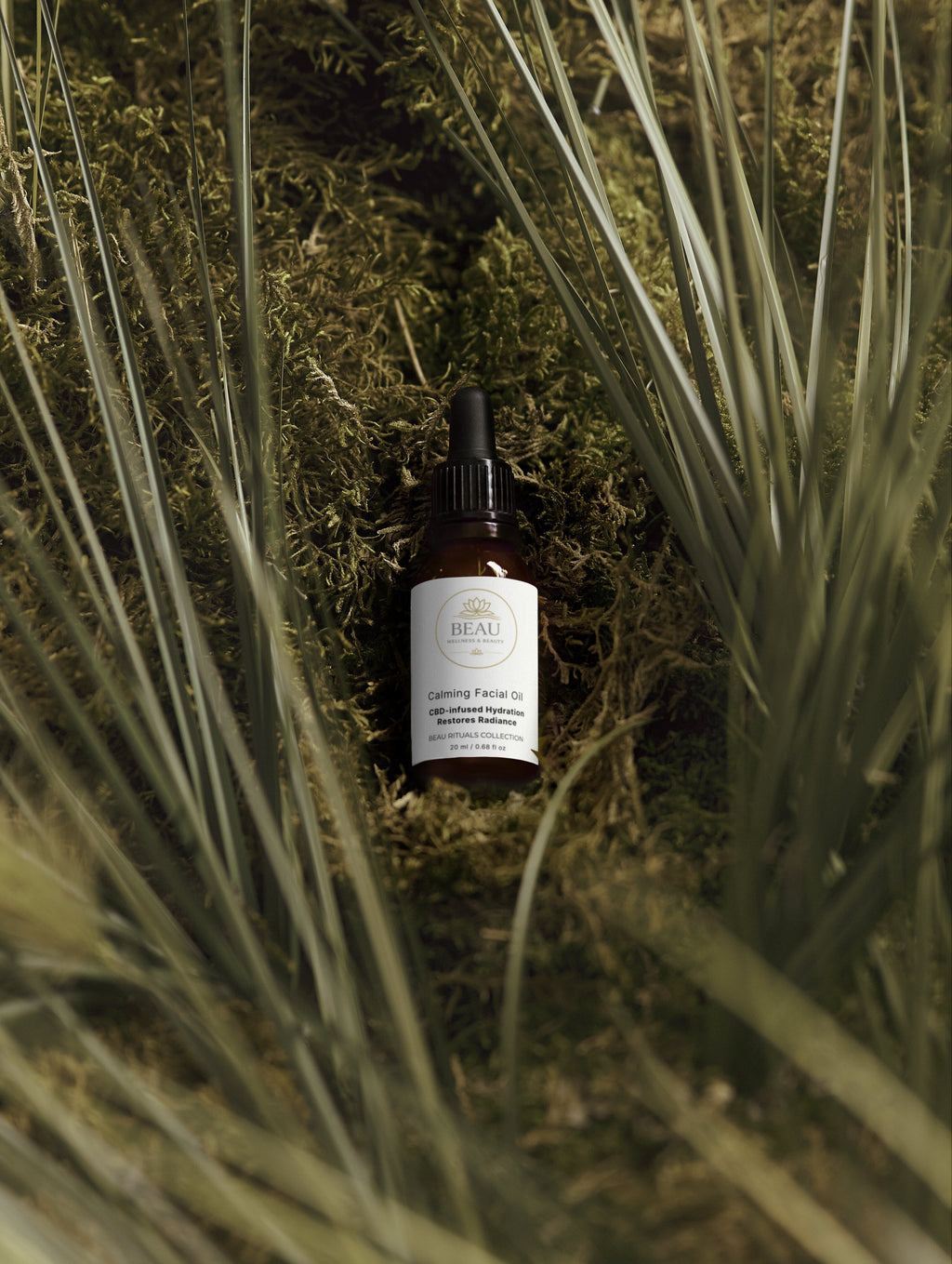 Bottle of Beau Wellness & Beauty Calming Facial Oil – CBD and Hemp Seed oil for stressed skin. on a grassy background