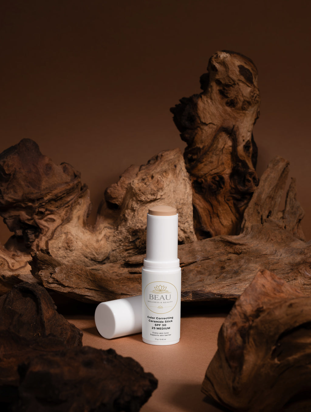 Beau Wellness & beauty CC Ceramide Stick with SPF 30 , shade medium 25 on wooded background.