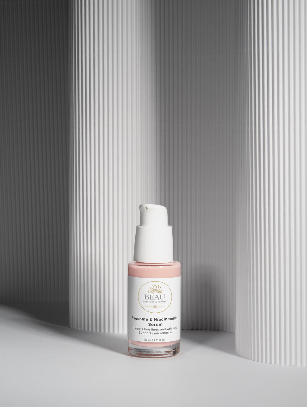 Beau Wellness & Beauty Exosome and Niacinamide Skincare serum bottle placed in a modern, minimalist gray architectural setting with clean geometric lines and shadows.
