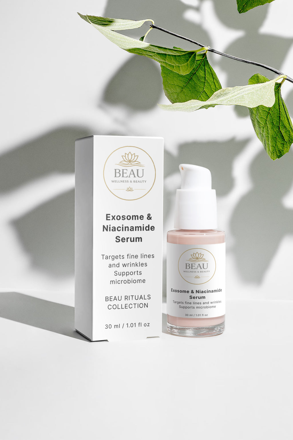 Beau Wellness & Beauty Exosome & Niacinamide Serum pump bottle and white product box styled on a bright white surface with dramatic leaf shadows and green foliage.
