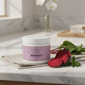 Beau Wellness Beetroot Powder drink mix with hibiscus flower and apple juice powder for cardiovascular health, normal blood pressure, and workout recovery support with fresh beets on marble counter background.
