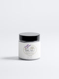 Minimalist white glass jar of BEAU Calm Ritual Lavender Candle with a black lid and floral botanical illustration.