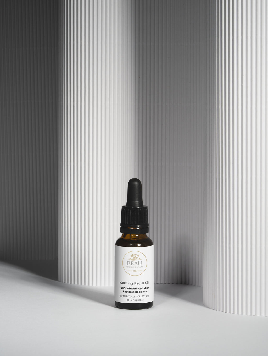 Bottle of Beau Wellness & Beauty Calming Facial Oil – CBD and Hemp Seed oil for stressed skin. on a gray background