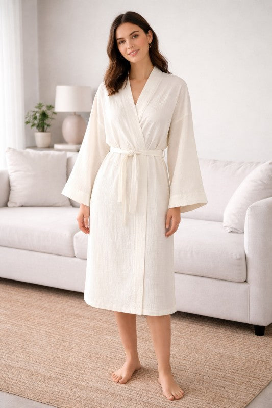 Woman wearing a white Cotton Muslin Wrap Robe in a living room setting