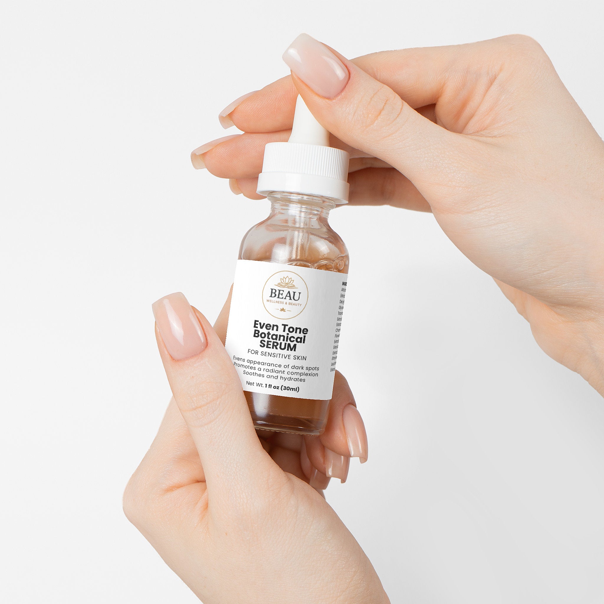 Beau Wellness and Beauty Even Tone Botanical Serum for Sensitive Skin. A gentle brightening formula powered by Jackfruit, adaptogenic mushrooms, and sea fennel to target dark spots without irritation. Held by two hands with a white background