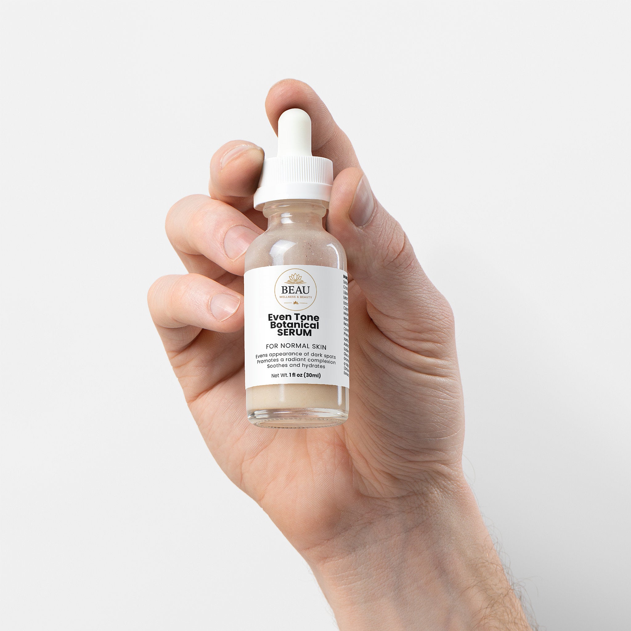 Even Tone Botanical Serum for normal skin.  high-performance brightening serum featuring kojic Acid, Niacinamide, and antioxidant-rich pomegrante seed oil held in hand