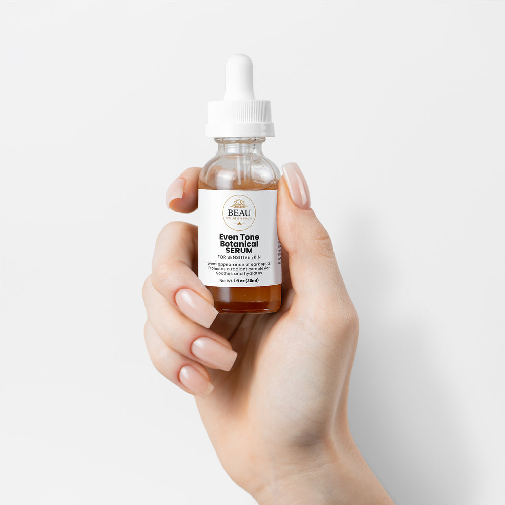 Beau Wellness and Beauty Even Tone Botanical Serum for Sensitive Skin. A vegan and gluten free, gentle brightening formula powered by Jackfruit, adaptogenic mushrooms, and sea fennel to target dark spots without irritation. Held in hand with white background.