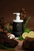 Beau Wellness & Beauty Keratin Volume Boost Shampoo bottle with pump on a brown background with mushrooms, rosemary, bergamot, and mint.