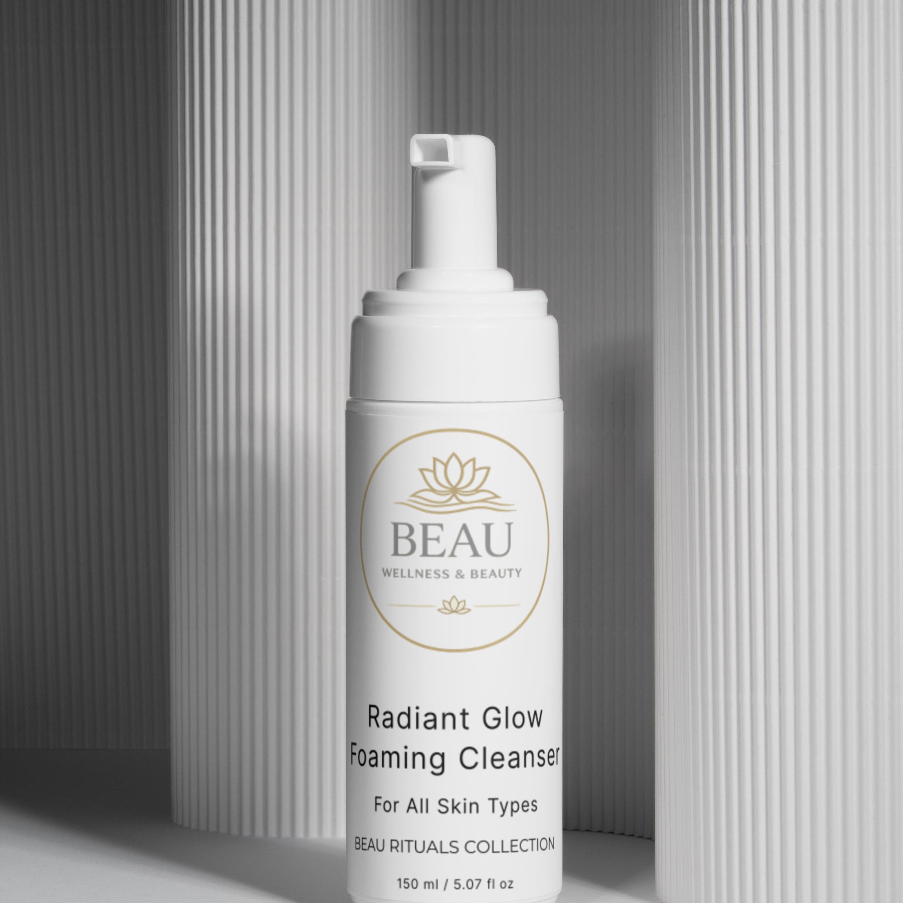 Beau Wellness & Beauty Radiant Glow foaming Cleanser bottle on a neutral column background