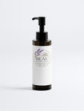 Minimalist white jar of BEAU Omega 6-9 Glowing Skin Body Oil with lavender botanical branding on a clean white background.
