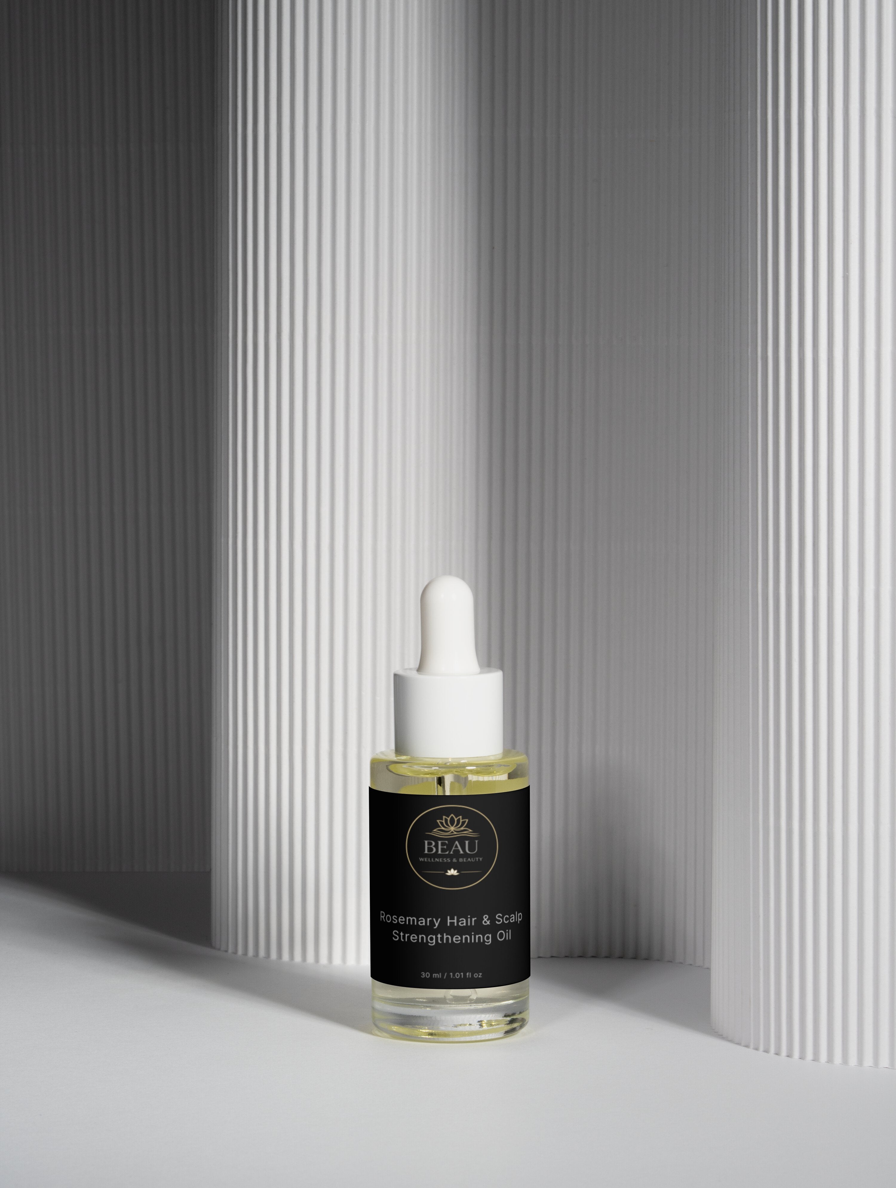 Beau Wellness & Beauty Rosemary Hair and Scalp Strengthening Oil in a clear glass dropper bottle with luxury black and gold branded label.